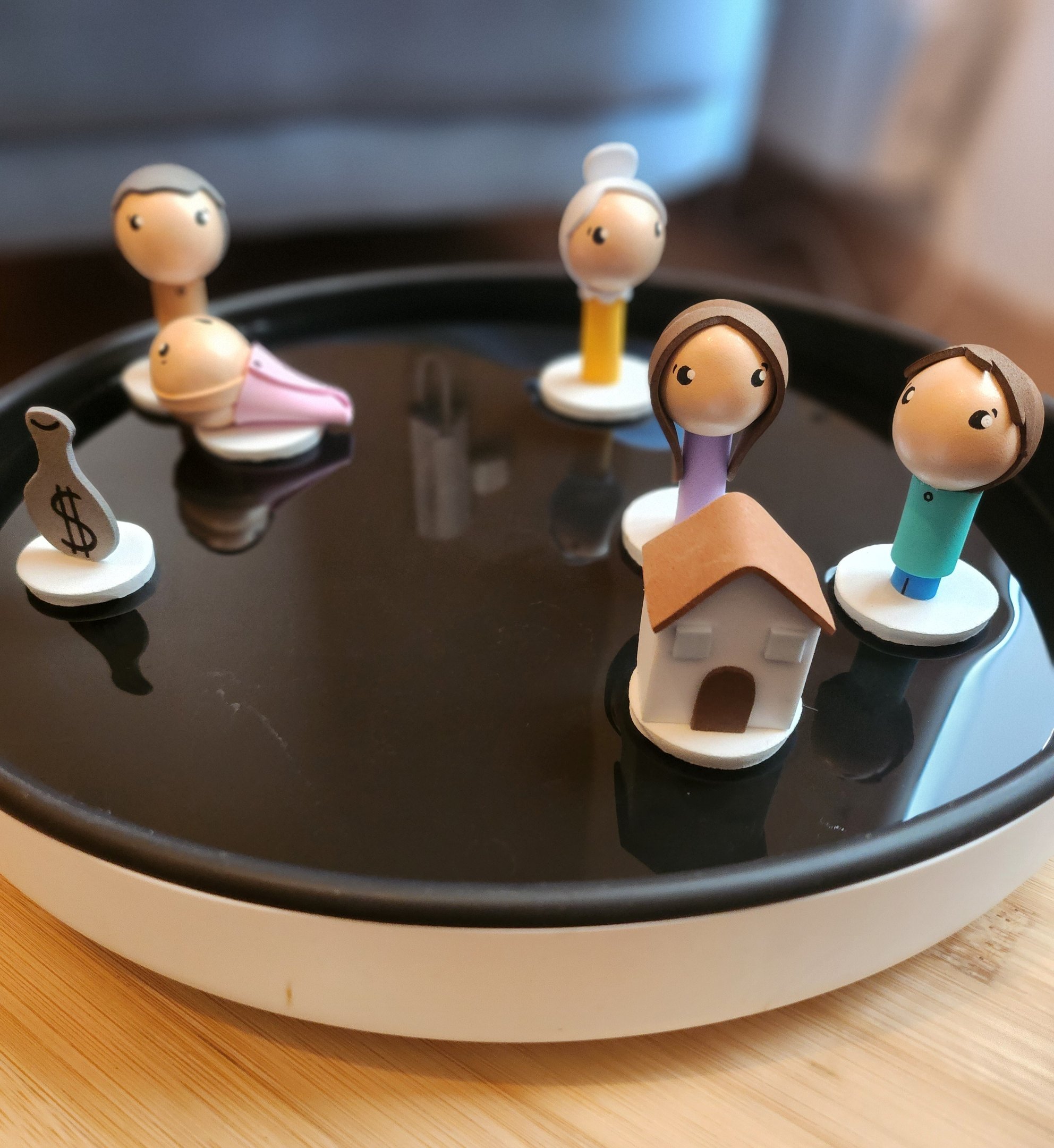Figurines représentant une famille disposées sur l’eau pendant une séance de constellation
